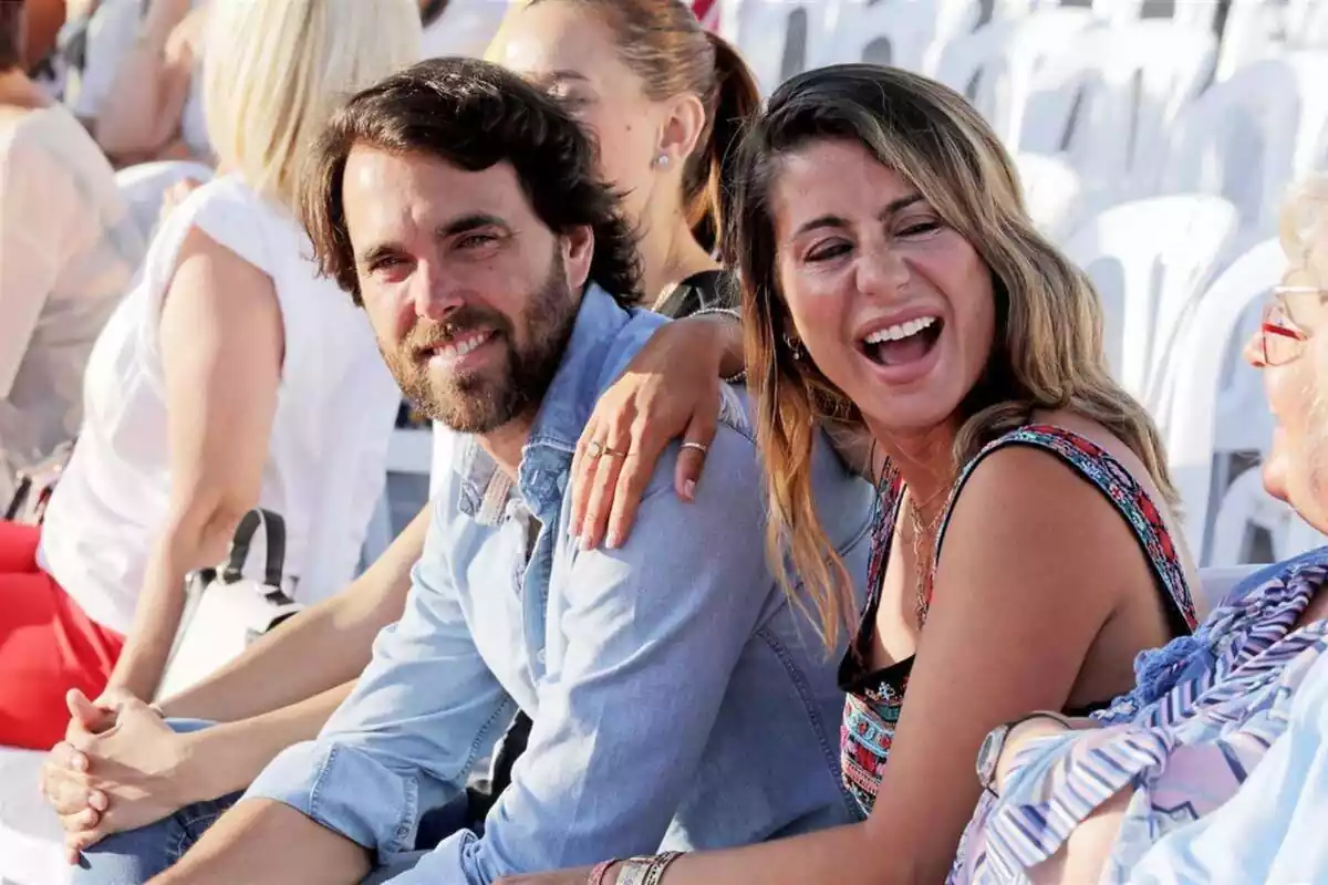 Javier Ungría y Elena Tablando riendo sentados en unas sillas blancas