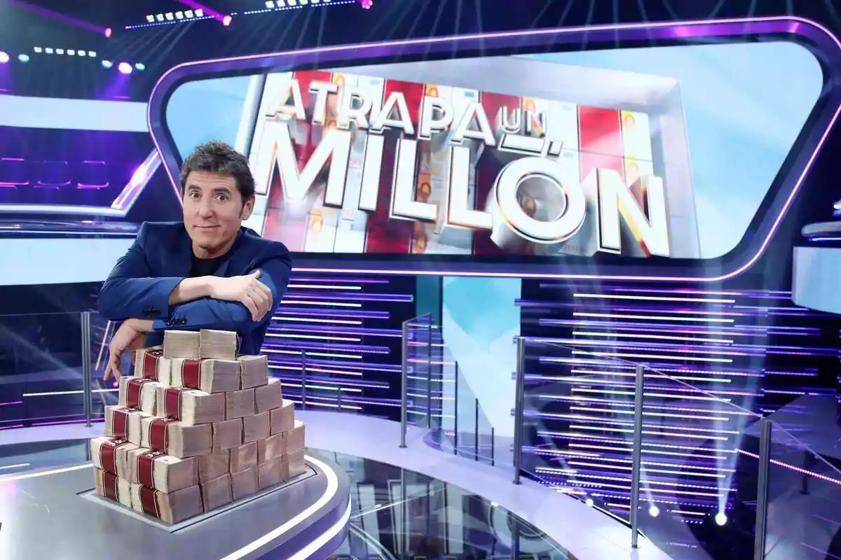 Manel Fuentes junto a fajos de billetes en Atrapa un Millón de Antena 3